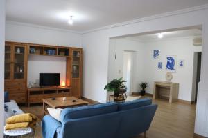 a living room with a blue couch and a tv at Casa La Vuelta in Águilas