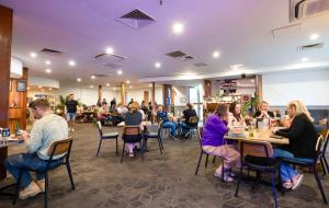 a group of people sitting at tables in a restaurant at Nightcap at Roxby Downs in Roxby Downs