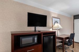 een hotelkamer met een televisie en een bureau met een stoel bij Days Inn by Wyndham Columbia Kentucky in Columbia