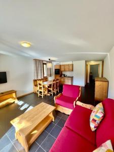 uma sala de estar com um sofá vermelho e uma mesa em Apparthotel Mountain River Resort em Val dʼIlliez
