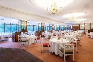 Hyatt Regency Harare The Meikles في هراري: غرفة طعام مع طاولات وكراسي بيضاء