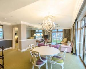 a dining room and living room with a table and chairs at Meikles Hotel in Harare