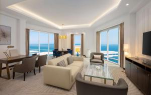 uma sala de estar com um sofá e uma mesa em Hilton Al Khobar King Fahd Causeway em Al Khobar