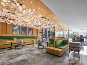 un vestíbulo de un restaurante con mesas y sillas en Hilton Garden Inn Jinzhong Yuci en Jinzhong