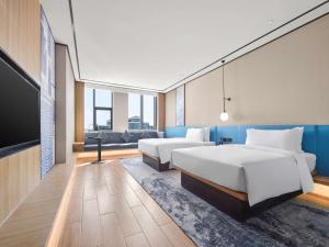 Habitación de hotel con 2 camas y TV de pantalla plana. en Hilton Garden Inn Jinzhong Yuci, en Jinzhong