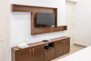 a living room with a tv on a wall at La Woods Village Resort in Tiruvannāmalai