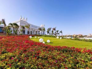 a building with a field of flowers in front of it at Rixos Radamis Sharm El Sheikh in Sharm El Sheikh