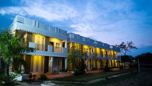a large white building with lights on at La Woods Village Resort in Tiruvannāmalai