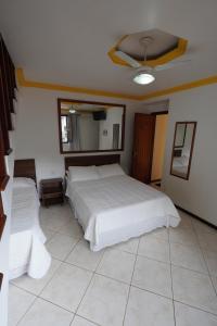 a bedroom with two beds and a ceiling fan at Pousada Juliana in Abraão