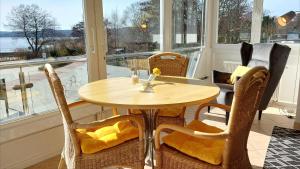 einen Holztisch und Stühle in einem Zimmer mit Fenstern in der Unterkunft Villa Schwan by Rujana in Binz