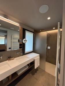 a bathroom with a sink and a mirror and a shower at Agriturismo Vedova in Valdobbiadene