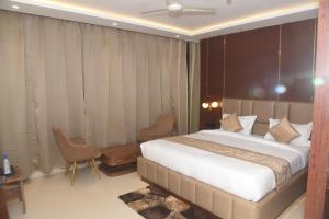 um quarto com uma cama grande, uma mesa e cadeiras em HOTEL LAWANG SIGNAGE em Deoghar