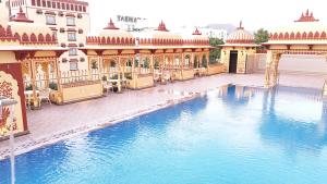 a large swimming pool in front of a building at Umaid Haveli-A Heritage Style Hotel & Resort in Jaipur