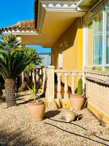 Chalet La Calma en Lorca في لوركا: منزل مع نباتات الفخار على الشرفة الأمامية