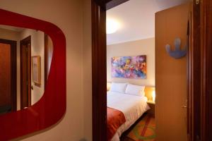 Habitación de hotel con cama y espejo en Apartamento SpítiCasa, en Santiago de Compostela