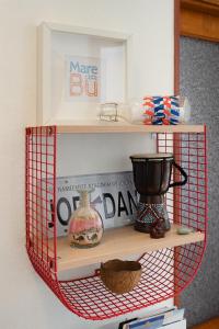 a red wire shelf with books and a blender on it at [Free Parking] Un angolo di sole a MareBu! in Rapallo