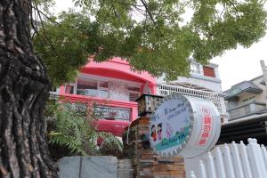 a pink house with a sign in front of it at Qing Noise Villas in Hualien City