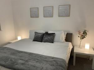 um quarto com uma cama com três fotografias na parede em Spacious Apartment - Contractors and Family - LGW em Horley