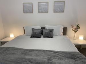 un letto bianco con tre cuscini sopra di Spacious Apartment - Contractors and Family - LGW a Horley