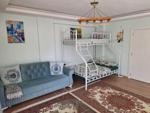 a living room with a blue couch and a shelf at Family Apart-Hotel 2022 - 6 in Antalya