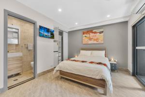 a bedroom with a large bed and a bathroom at Brand New Furnished Studios in Padstow