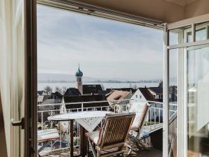 balcón con mesa, sillas y vistas a la ciudad en Ferienwohnung Bodenseeblick, en Allensbach