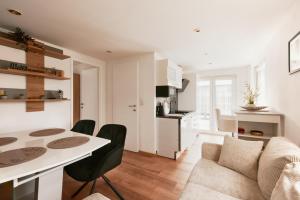 uma cozinha e sala de estar com uma mesa e um sofá em Exclusive 3BD Chalét in Premium Location of Vienna w/ Sauna Swimming Pool Jaccuzi em Viena