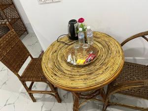 una mesa redonda de ratán con 2 sillas y una mesa en El Ling guesthouse en Kep