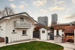 ein weißes Haus mit Garten mit Rasen in der Unterkunft Exclusive 3BD Chalét in Premium Location of Vienna w/ Sauna Swimming Pool Jaccuzi in Wien