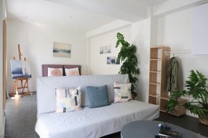 a living room with a white couch with pillows at One Apartment by Skg Apartments in Thessaloniki