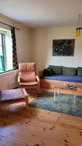 un soggiorno con divano e sedia di Alte Ausspanne FEWO a Walkendorf