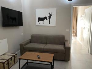 una sala de estar con sofá y un hombre con un caballo en Residenza Segrate Centro Novegro en Segrate