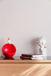 a shelf with books and a red bowl and a stack of books at [Free Parking] Un angolo di sole a MareBu! in Rapallo +15 photos