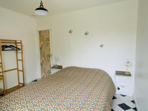 1 dormitorio con 1 cama en una habitación blanca en Rue des roses en Saint-Pierre-dʼOléron
