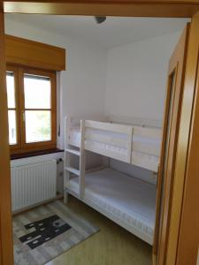 ein weißes Etagenbett in einem Zimmer mit Fenster in der Unterkunft Raus aufs Land in Ederberg