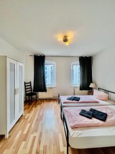 een slaapkamer met 2 bedden en een houten vloer bij Central City West in Berlijn