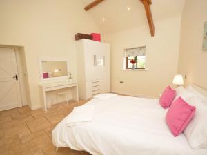 a bedroom with a large white bed with pink pillows at 2 Bed in South Molton 62654 in Filleigh