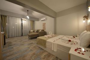 Habitación de hotel con cama y sala de estar. en TRAKHEİA OTEL en Marmaris