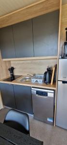 a small kitchen with a sink and a refrigerator at Mobile Homes Albatross Pirovac in Pirovac