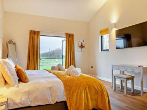 Babcary的住宿－2 Bed in Somerton 92126，一间卧室配有一张带书桌的床和窗户。