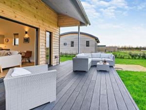 a patio with white wicker furniture on a wooden deck at 2 Bed in Somerton 92126 in Babcary