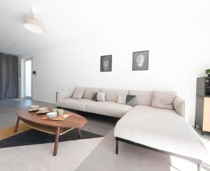 a living room with a couch and a coffee table at Villa Horizon - climatisation et jardin in Lattes