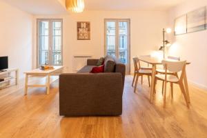 een woonkamer met een bank en een tafel bij Coeur urbain - centre historique in Montpellier