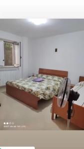 sypialnia z łóżkiem, krzesłem i oknem w obiekcie Da Totonno w mieście Montefalcione