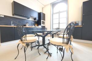 una cucina con tavolo in vetro e 4 sedie di Room Jade - La Maison de la duchesse de la Valliere - Parking privé a Mons