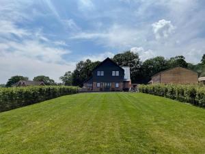 a large grassy yard with a house in the background at 4 Bed in Maresfield 56696 in Maresfield