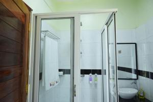 ein Bad mit einer Dusche und einem Waschbecken in der Unterkunft ESCAPE VILLAGE HOTEL in Yumbe