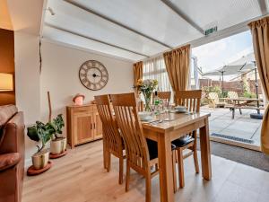a dining room with a wooden table and chairs at 2 Bed in Saundersfoot 94207 in Saundersfoot