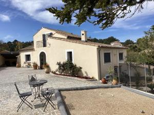 a house with chairs and a table in front of it at Mas Madilauric 2 BNB in Peymeinade