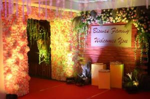 un escenario con flores y una señal que lee las fiestas nupciales en HOTEL SHOOLIN GRAND, en Guwahati